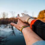 A couple embracing a romantic moment by a serene lake, captured at sunset with a warm, loving vibe.